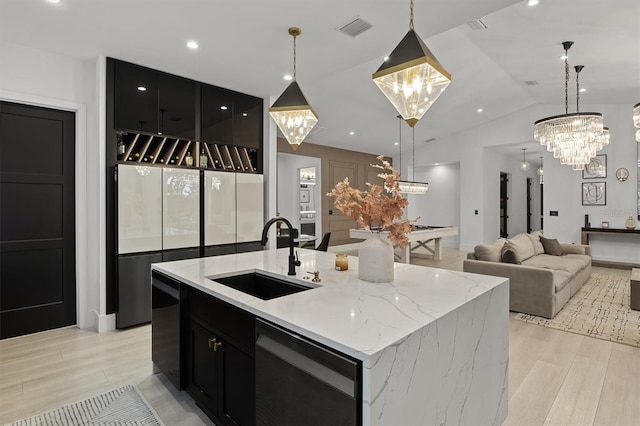 kitchen featuring a center island with sink, hanging light fixtures, and sink