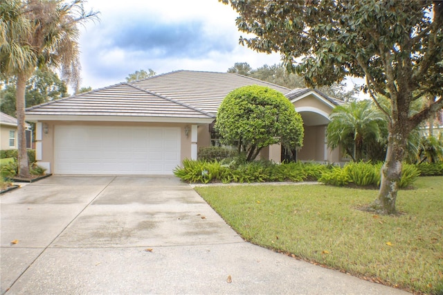 view of front of home with a garage and a front lawn