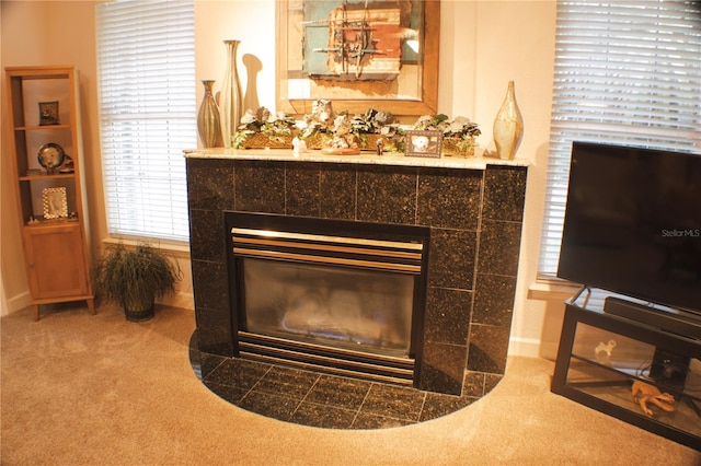 interior details with a tiled fireplace and carpet floors