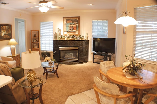 carpeted living room with crown molding, a healthy amount of sunlight, and a fireplace