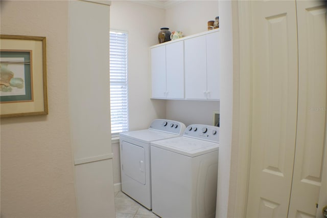 laundry area featuring cabinets, washing machine and clothes dryer, light tile patterned floors, and plenty of natural light