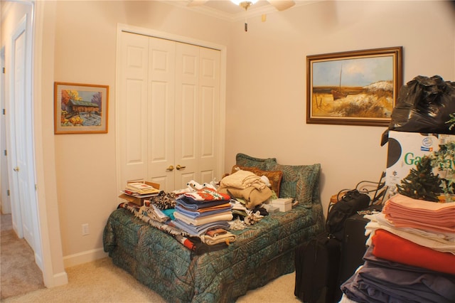 carpeted bedroom with ceiling fan, a closet, and ornamental molding