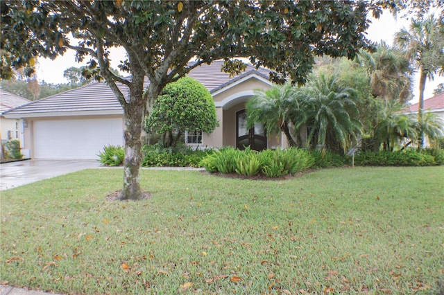 view of property hidden behind natural elements with a front yard and a garage