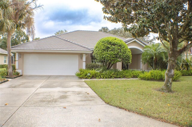 108 Lake Region Blvd N, Winter Haven, FL 33881 - single story home with stucco siding, a front lawn, driveway, a garage, and a tile roof