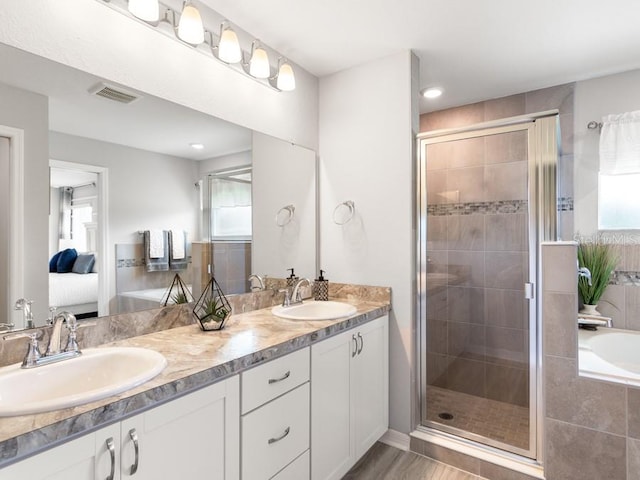 bathroom featuring vanity, hardwood / wood-style floors, a healthy amount of sunlight, and a shower with shower door