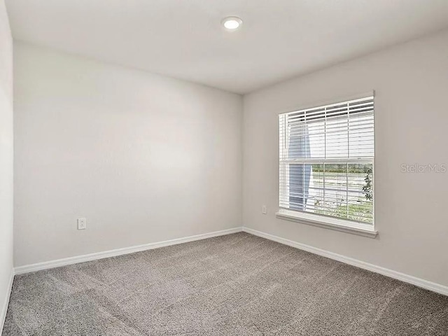 carpeted empty room with baseboards
