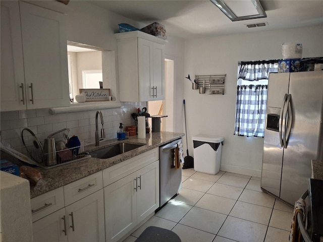 kitchen with stone countertops, appliances with stainless steel finishes, sink, and white cabinets