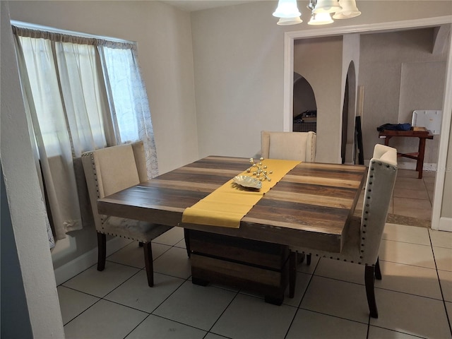 tiled dining space with a chandelier