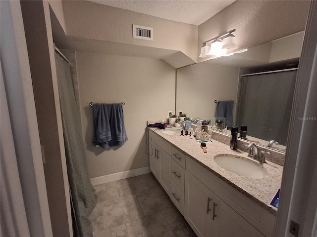 bathroom with vanity, tile patterned floors, and a textured ceiling