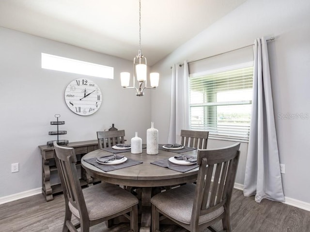 dining area with dark hardwood / wood-style flooring and a notable chandelier