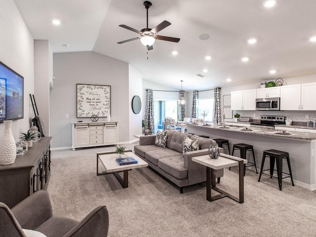 living room featuring light carpet, ceiling fan, and vaulted ceiling