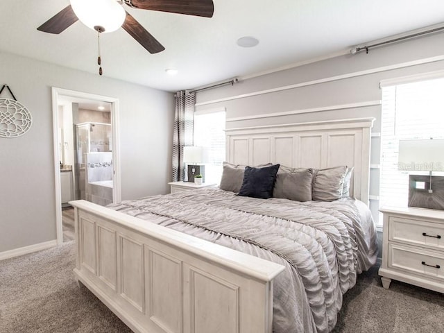 bedroom featuring ensuite bath, ceiling fan, multiple windows, and dark carpet