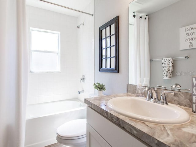 full bathroom featuring vanity, toilet, and tiled shower / bath combo