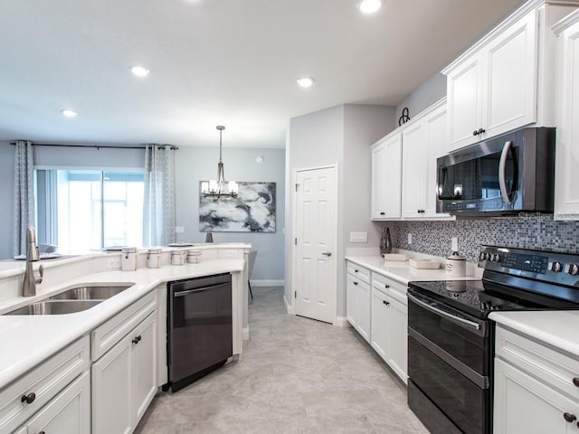 kitchen with white cabinetry, sink, black appliances, pendant lighting, and decorative backsplash