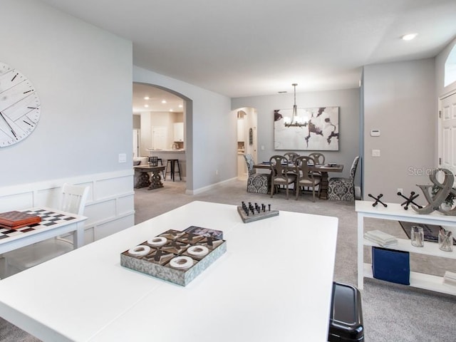 interior space featuring a kitchen island, hanging light fixtures, an inviting chandelier, and carpet floors