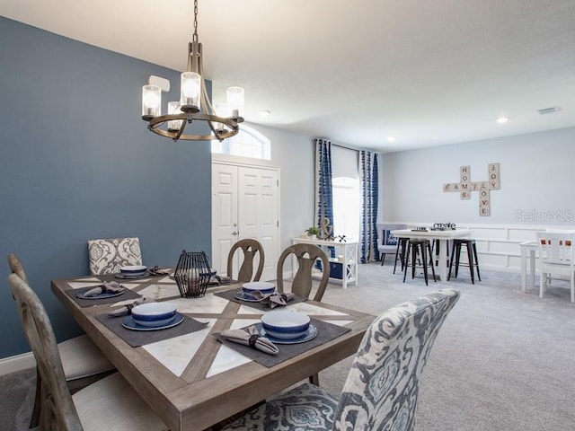 carpeted dining space with a notable chandelier