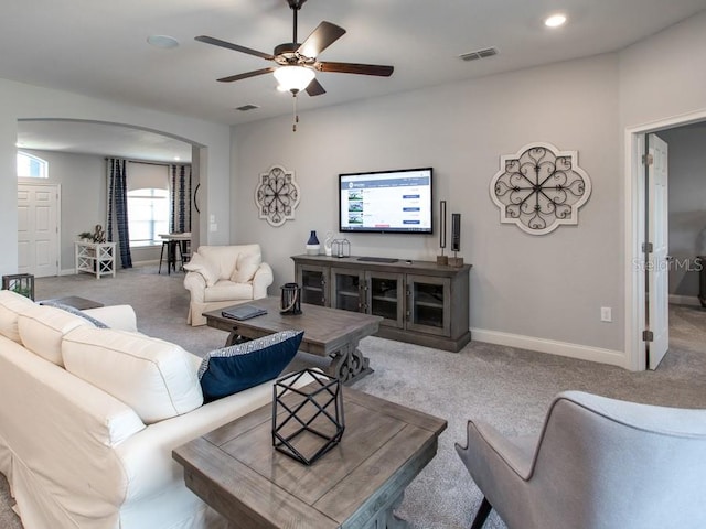 carpeted living room with ceiling fan