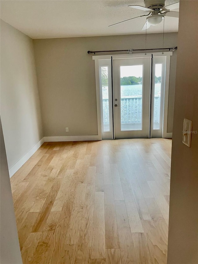 unfurnished room with light wood-type flooring and ceiling fan