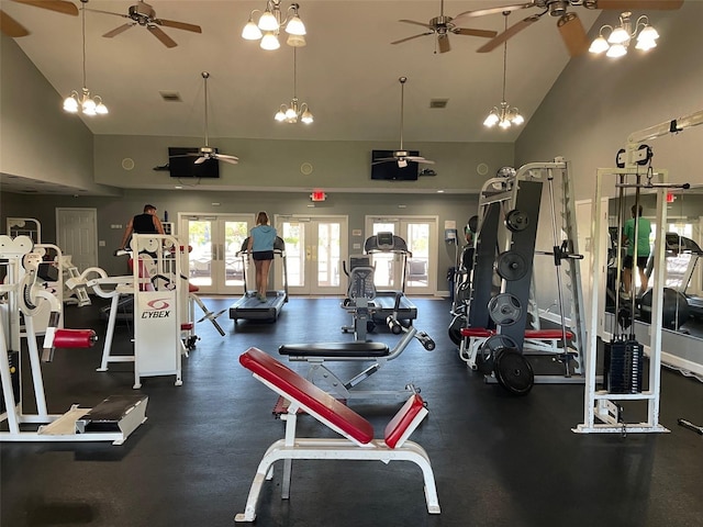 exercise room featuring french doors, ceiling fan with notable chandelier, high vaulted ceiling, and a healthy amount of sunlight