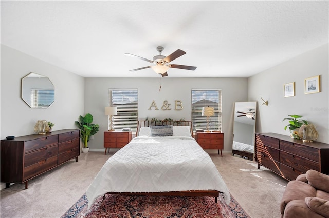 carpeted bedroom featuring multiple windows and ceiling fan