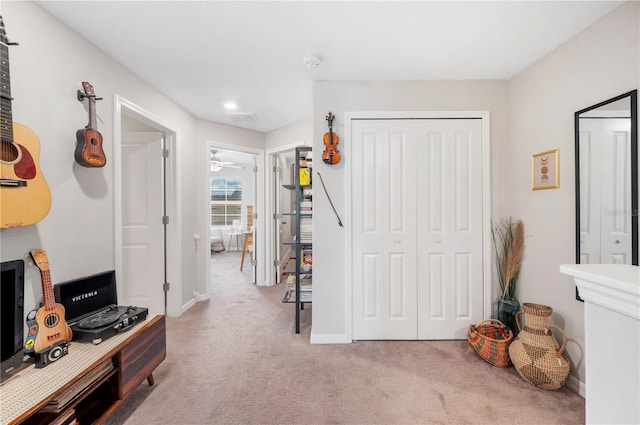 interior space featuring light colored carpet and ceiling fan