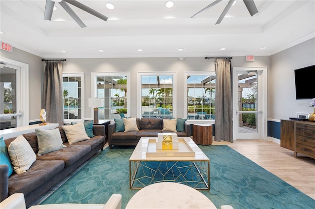 living room featuring hardwood / wood-style floors, a healthy amount of sunlight, crown molding, and a tray ceiling