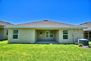 rear view of house with a lawn, cooling unit, and a patio