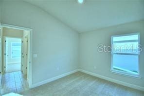 interior space featuring light colored carpet and vaulted ceiling