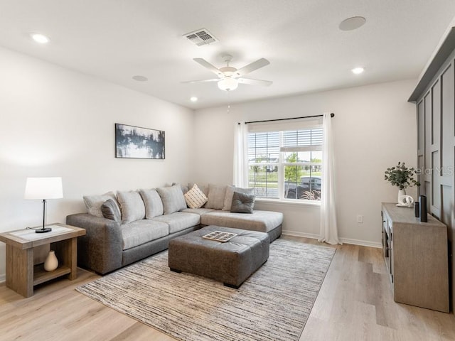 living room featuring light hardwood / wood-style floors and ceiling fan