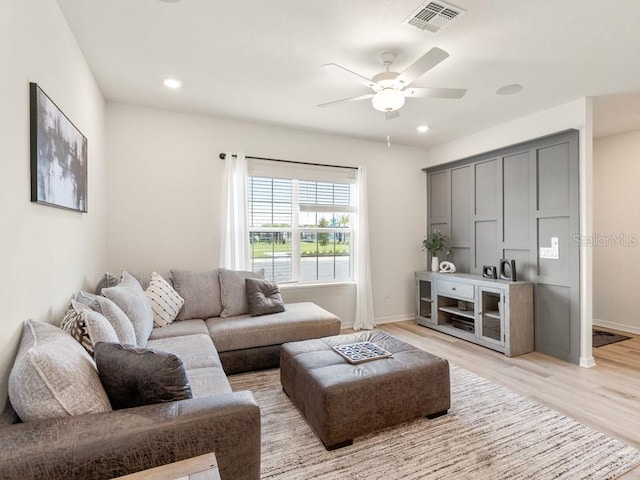 living room featuring ceiling fan and light hardwood / wood-style floors