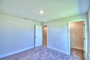 unfurnished bedroom featuring carpet floors and a closet