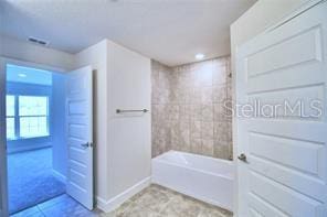 bathroom with tub / shower combination and tile patterned flooring