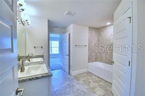 bathroom with vanity and shower / washtub combination