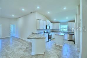 1580 Leamington Ln, Winter Haven, FL 33884 - kitchen featuring appliances with stainless steel finishes, white cabinetry, a center island, a peninsula, and recessed lighting