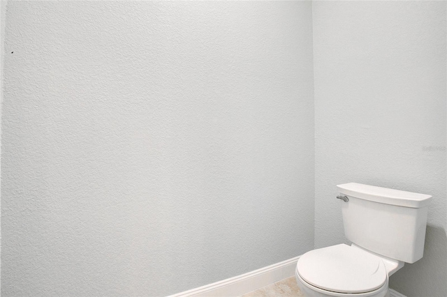 bathroom featuring toilet and tile patterned flooring