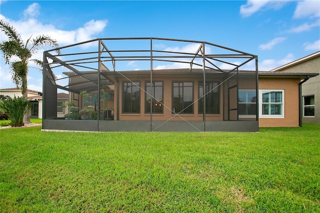 rear view of house with a yard and glass enclosure