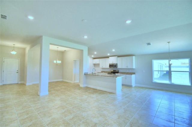 unfurnished living room with light tile patterned floors, a chandelier, and sink