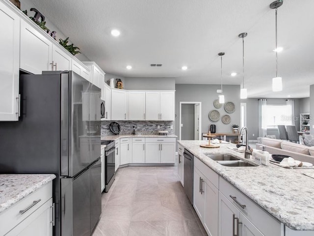 kitchen featuring white cabinetry, appliances with stainless steel finishes, sink, and pendant lighting