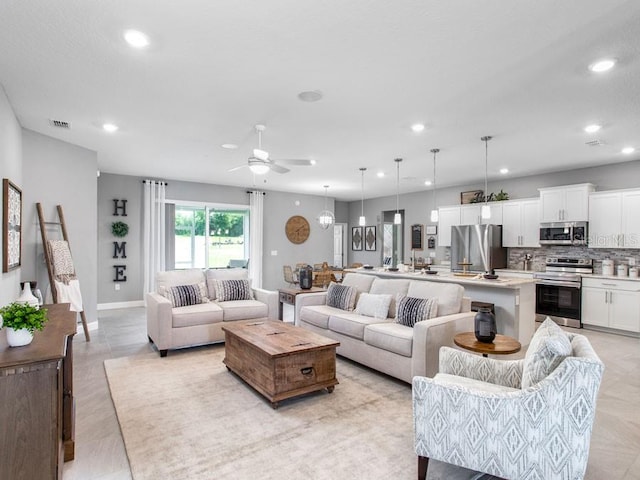 living room featuring light wood-type flooring and ceiling fan