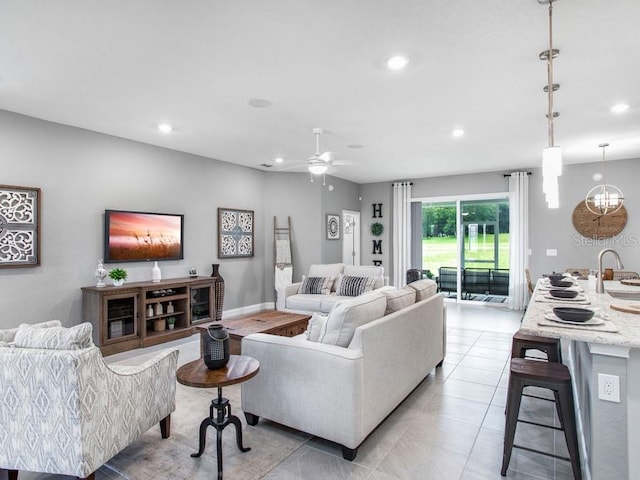 tiled living room with ceiling fan and sink