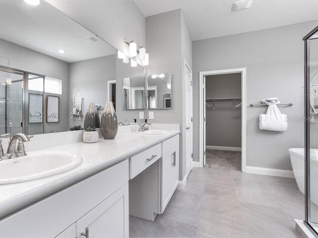 bathroom with tile patterned flooring, vanity, plus walk in shower, and a textured ceiling