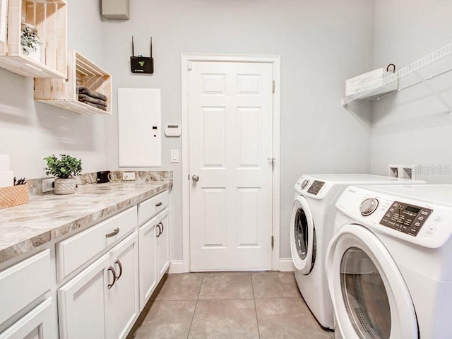 laundry area with cabinets, separate washer and dryer, and light tile patterned floors