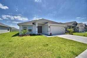 single story home with a garage and a front lawn