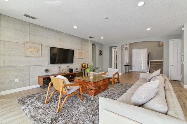 living room featuring a textured ceiling and light hardwood / wood-style floors