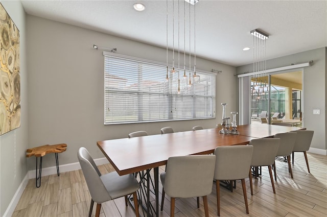 dining room featuring light hardwood / wood-style flooring and a textured ceiling