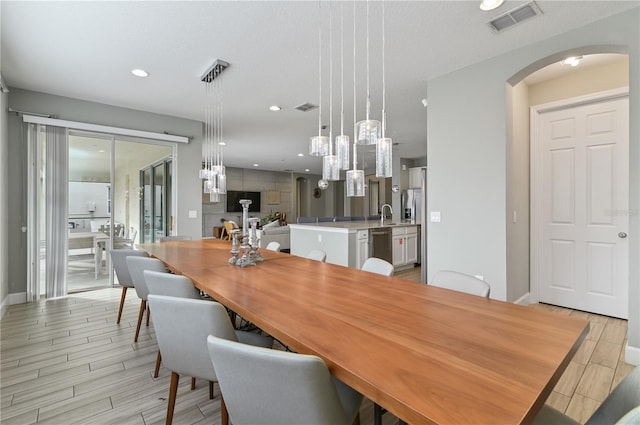 dining room with light wood-type flooring and a textured ceiling