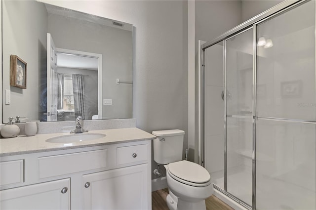 bathroom featuring an enclosed shower, wood-type flooring, toilet, and vanity