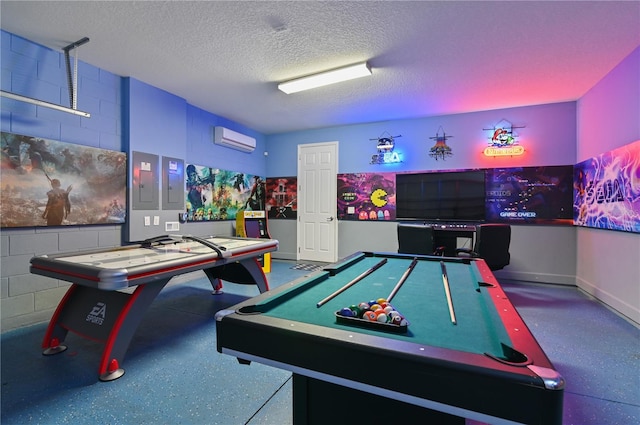 recreation room with pool table, an AC wall unit, and a textured ceiling