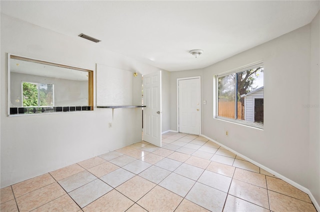 tiled empty room with a healthy amount of sunlight