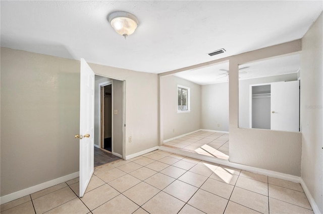 tiled empty room featuring ceiling fan